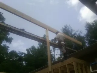 Carpenter setting a ridge beam over a new addition frame — Ice Dam Removal by Roofing Brothers in Tillamook